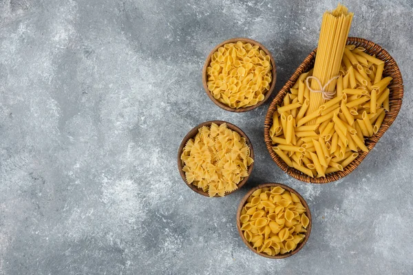 Pile Various Uncooked Dry Pasta Wicker Basket Wooden Bowls High — Stock Photo, Image