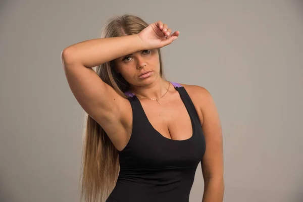 スポーツブラジャーの女性モデルは額に手を置き 疲れて見える 高品質の写真 — ストック写真