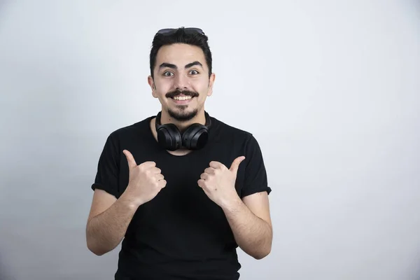 Brunette Man Model Standing Headphones Showing Thumbs White Wall High — Stok Foto