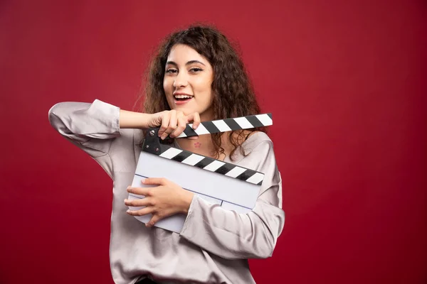 Curly Haired Woman Holding Clapperboard Red Background High Quality Photo — Stock Photo, Image