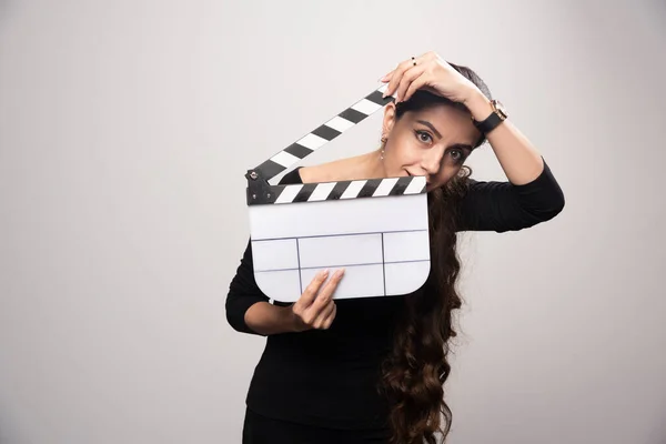 一个电影制作女孩拿着一块敞着的拍板从里面看过去 高质量的照片 — 图库照片