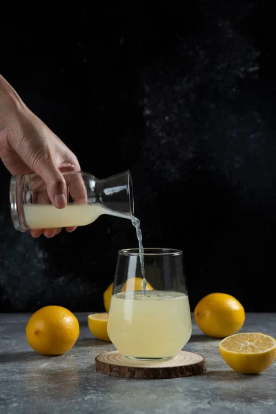コップにレモン汁を注ぐ手 高品質の写真 — ストック写真