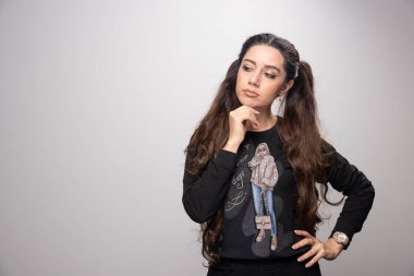 Parmak izi eşofmanlı genç kız gri arka planı derin düşünüyor. Yüksek kalite fotoğraf