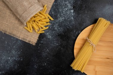 Köy sepetinde makarna ve ahşap tabakta spagetti. Yüksek kalite fotoğraf