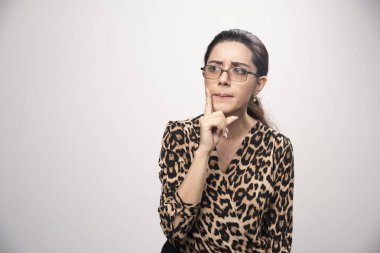 Leopar desenli tişörtlü kız, profesyonel tarzda gri arka planda poz veriyor. Yüksek kalite fotoğraf