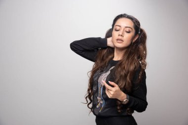 Genç bir kadın boynunu tutuyor ve çok güzel duruyor. Yüksek kalite fotoğraf