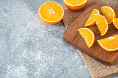 Taş zemin üzerinde portakal suyu dilimleriyle dolu tahta bir tahta. Yüksek kalite fotoğraf