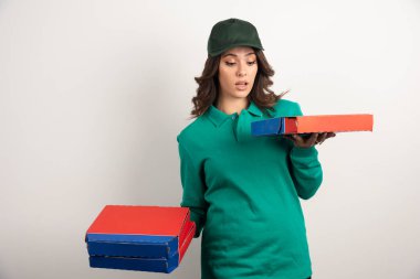 Teslimatçı kadın şaşırtıcı bir şekilde pizzaya bakıyor. Yüksek kalite fotoğraf