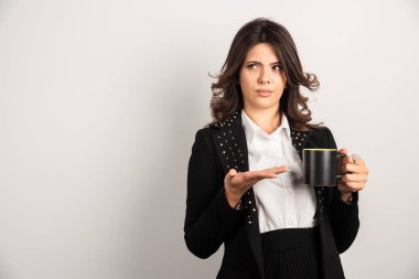 Kızgın bir ifadeyle elinde çay tutan kadın işçi. Yüksek kalite fotoğraf