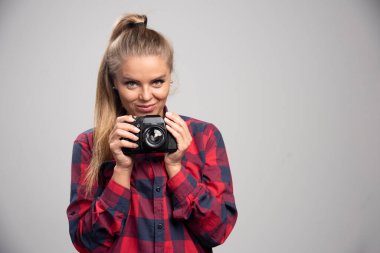 Damalı gömlekli sarışın fotoğraf, fotoğraf çekiyor ve olumlu hissediyor. Yüksek kalite fotoğraf