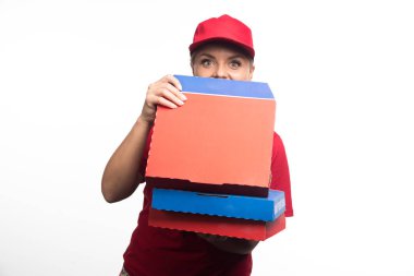 Pozitif teslimatçı kadın beyaz arka planda pizza kutuları açıyor. Yüksek kalite fotoğraf