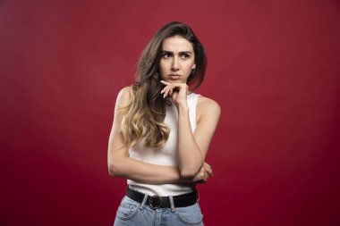 Kırmızı arka planda poz veren güzel esmer kadın model. Yüksek kalite fotoğraf