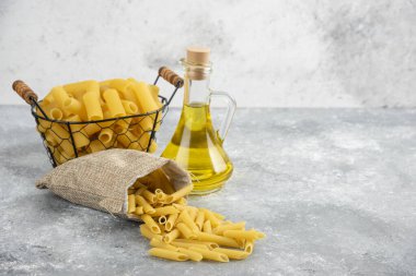 Metalik bir kapta, gri mermer zemin üzerinde zeytin yağı olan makarna. Yüksek kalite fotoğraf