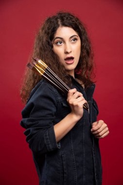 Boyalı fırçalı kıvırcık ressam bir şey yüzünden şoka giriyor. Yüksek kalite fotoğraf