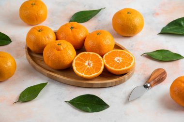 Clementine mandalinası ve yaprakları ahşap tabakta. Yüksek kalite fotoğraf