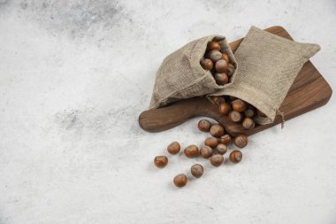 Tahta üzerinde çuval bezi içinde organik kabuklu fındık yığını. Yüksek kalite fotoğraf