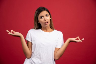 Kırmızı arka planda poz veren genç ve güzel bir kadın. Yüksek kalite fotoğraf