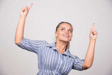 Genç bir kadın mutlu bir şekilde gri arka plana bakıyor. Yüksek kalite fotoğraf