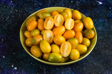 Mavi arka planda seramik kasede kumkatların yakın fotoğrafını çek. Yüksek kalite fotoğraf