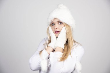 Kış kıyafetli sarışın kadın yüzünü tutuyor. Yüksek kalite fotoğraf