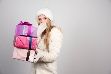 Kışlık kıyafetli genç bir kadın bir sürü hediye taşıyor. Yüksek kalite fotoğraf