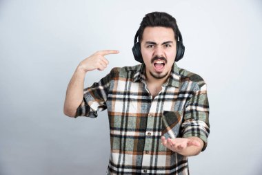 Kulaklıklı yakışıklı bir adam, kızgın bir ifadeyle kameraya bakıyor. Yüksek kalite fotoğraf