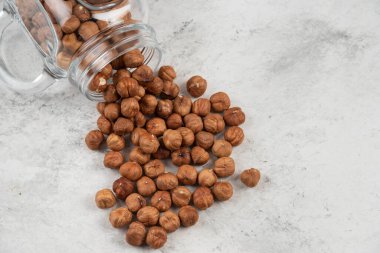Cam kavanozdaki organik fındık çekirdekleri mermer zemin üzerinde. Yüksek kalite fotoğraf