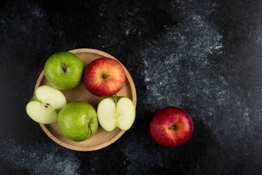 Tam ve dilimlenmiş yeşil ve ahşap tabakta kırmızı elmalar. Yüksek kalite fotoğraf