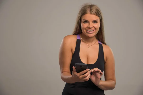 Modelo Feminino Mensagens Texto Sutiã Esporte Com Seu Smartphone Foto — Fotografia de Stock