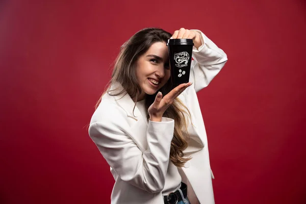Bizneswoman Pokazuje Filiżankę Kawy Czerwonym Tle Wysokiej Jakości Zdjęcie — Zdjęcie stockowe