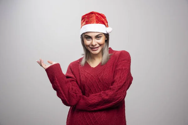Vrouw Met Kerstmuts Staat Gelukkig Grijze Achtergrond Hoge Kwaliteit Foto — Stockfoto