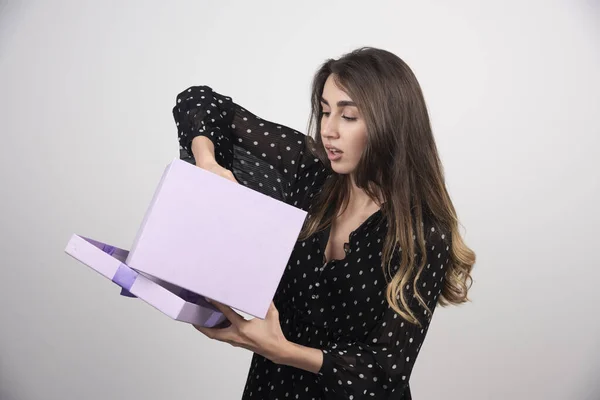 Mujer Joven Poniendo Mano Una Caja Regalo Púrpura Sobre Fondo — Foto de Stock