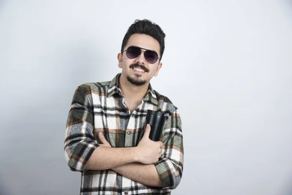 Foto Joven Con Gafas Mostrando Vaso Negro Sobre Una Pared — Foto de Stock