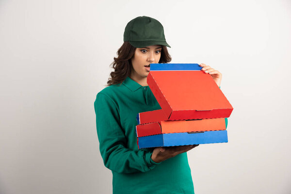 Delivery woman shockingly looking at pizza. High quality photo