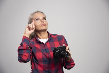 İşaretli tişörtlü sarışın fotoğraf düşünme işareti yapıyor. Yüksek kalite fotoğraf