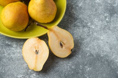 Beton bir arka planda armutlar ikiye bölünmüş. Yüksek kalite fotoğraf