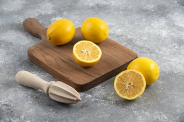 Tahta tahtadaki taze limonların limon sıkacağıyla fotoğrafını çek. Yüksek kalite fotoğraf