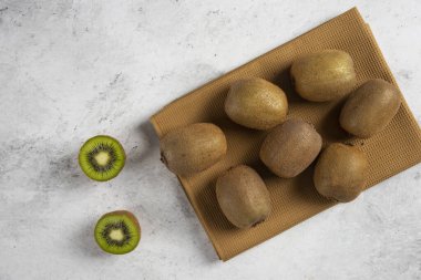 Kahverengi bir masa örtüsü üzerinde bir sürü taze kivi meyvesi. Yüksek kalite fotoğraf