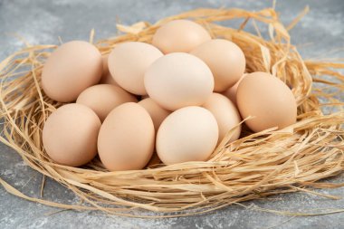 Mermer yüzeyinde kuş yuvası olan çiğ yumurtalar. Yüksek kalite fotoğraf