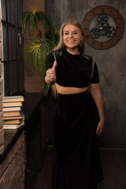 Pencerenin yanında kitaplarla poz veren genç bir kadın