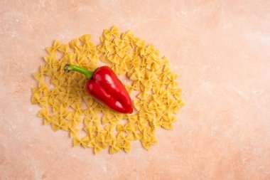 Turuncu arka planda kırmızı biberli farfalle makarnası. Yüksek kalite fotoğraf