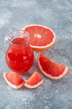 Bir sürahi taze greyfurt suyu ve bir dilim meyve. Yüksek kalite fotoğraf