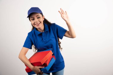 Elinde bir sürü pizza ve dosya olan genç bir kurye. 