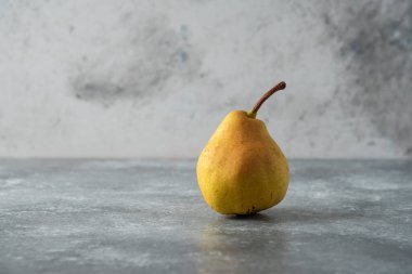 Beton zeminde tek bir sarı armut. Yüksek kalite fotoğraf