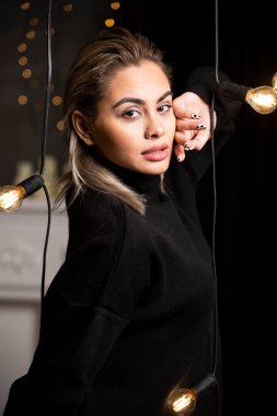 Ayakta duran ve lambaların yanında poz veren genç kadın portresi. Yüksek kalite fotoğraf