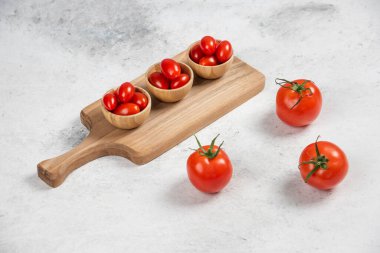 Tahta kaselerde taze kırmızı kiraz domatesleri. Yüksek kalite fotoğraf