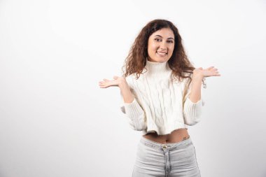 Beyaz kazaklı, kıvırcık saçlı genç bir kadın. Yüksek kalite fotoğraf