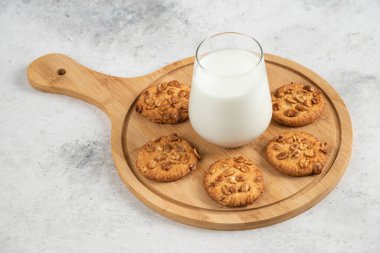 Organik fıstıklı lezzetli kurabiyeler ve tahtada taze sütle bal. Yüksek kalite fotoğraf