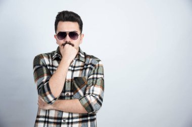 Siyah gözlüklü, beyaz arka planda duran genç adamın fotoğrafı. Yüksek kalite fotoğraf