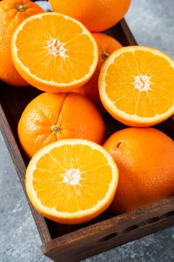 Dilimlenmiş ve sulu portakal meyveleriyle dolu ahşap bir kutu. Yüksek kalite fotoğraf